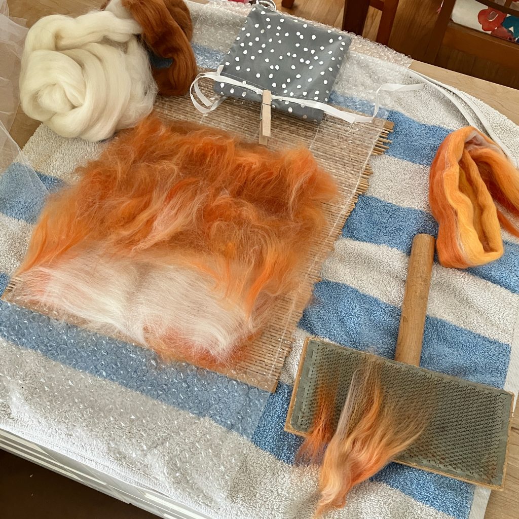 blending and laying out the loose wool fibres in order to wet felt them into a sheet