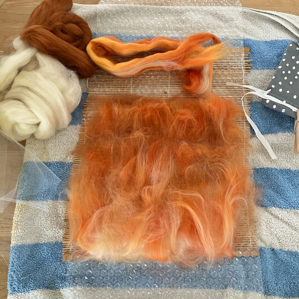 blending and laying out the loose wool fibres in order to wet felt them into a sheet