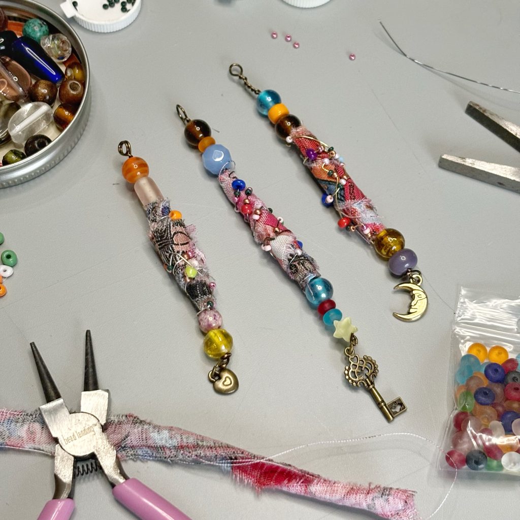 Three long beads made of glass beads, wrapped fabric strip and wire-wrapping with smaller beads