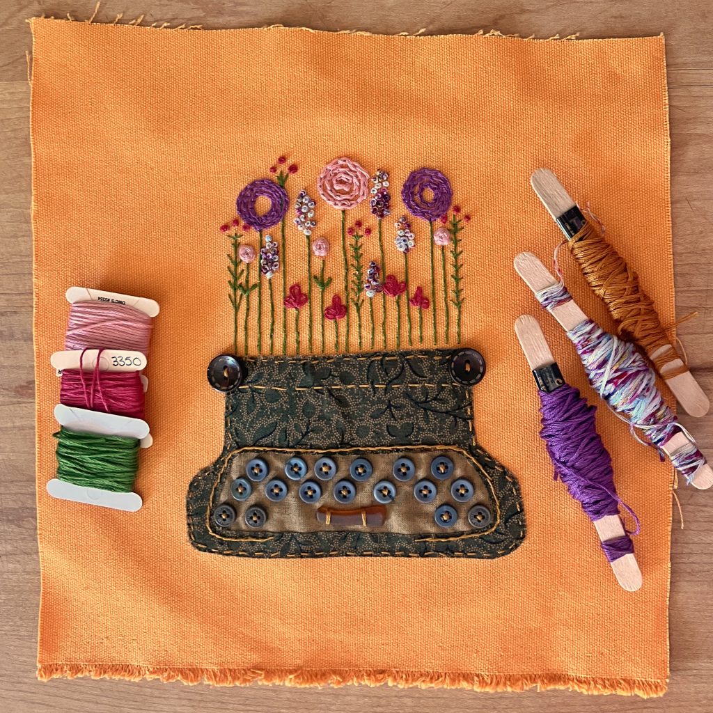 Textile art of manual typewriter with flowers growing out of it