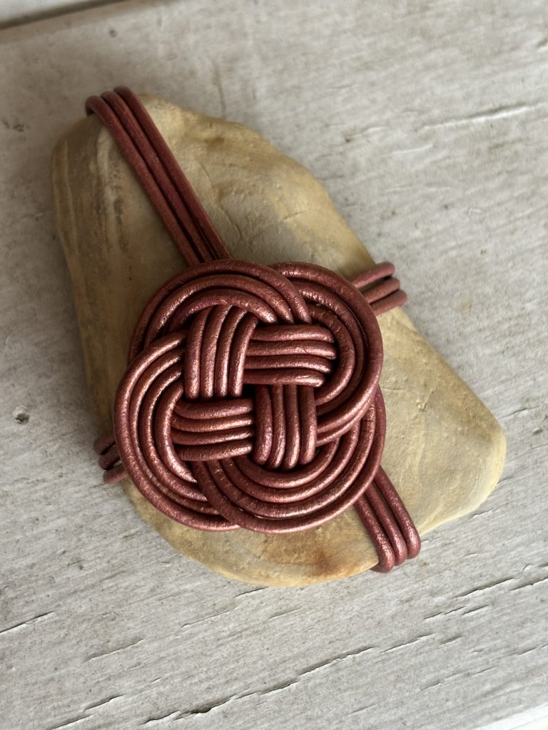 Brown leather cord in a carrick mat bend rock wrap