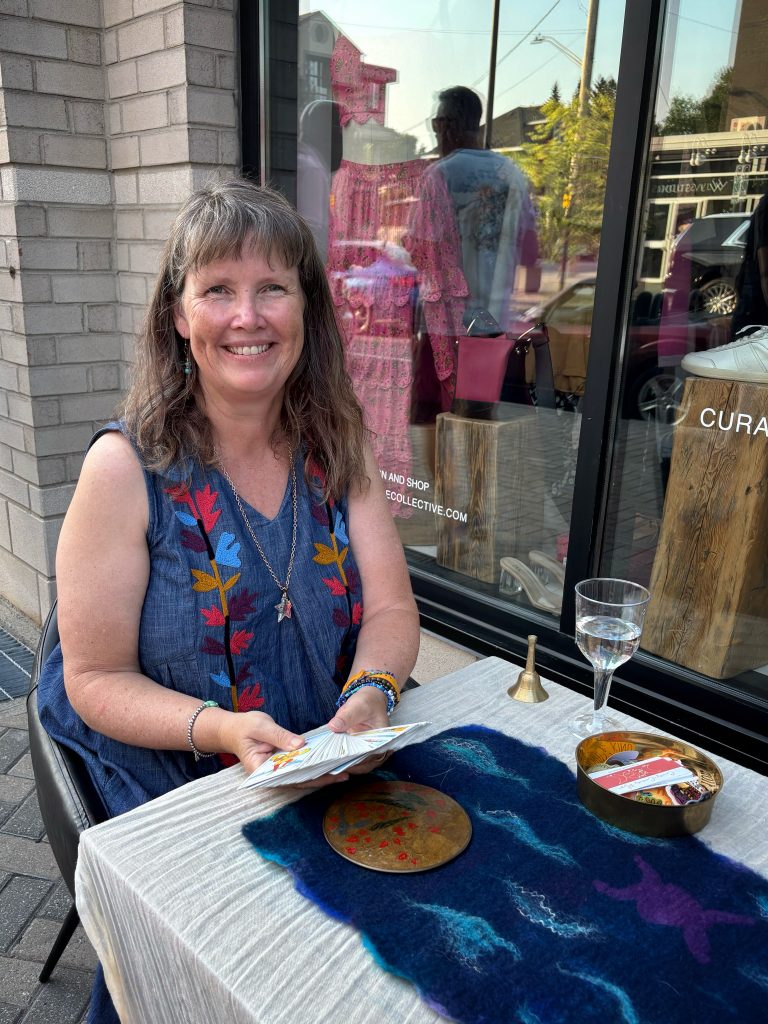 Dani smiling while doing tarot readings outside a shop in downtown Ottawa