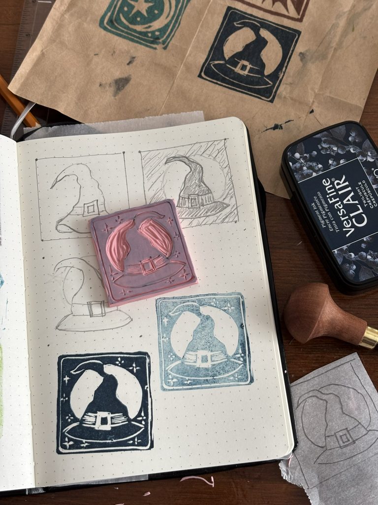 Playing with carving, inking and printing 2x2 inch linocut stamps. This one is a witch's hat.